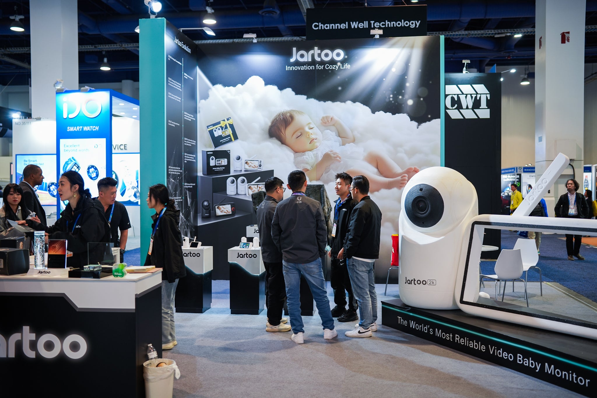 Stay connected at a glance: A hand holds a white baby monitor display, showing a clear, real-time feed of a happy baby playing in their crib. Perfect for instant peace of mind.